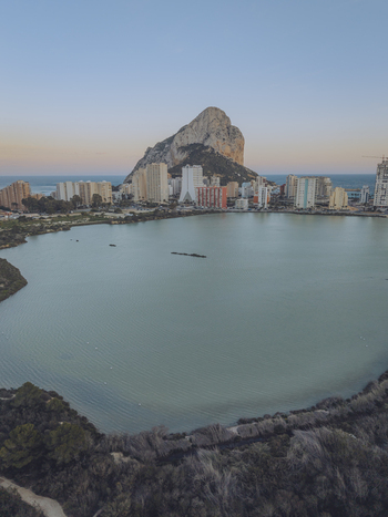 Aerial view of the Penyal d Ifac rock formation rising above the coastal city of Calp with high rise buildings and the Mediterranean Sea Calp Valencian Community Spain. Aerial view of the Penyal d Ifac rock formation rising above the coastal city of Calp with high rise buildings and the Mediterranean Sea Calp Valencian Community Spain.