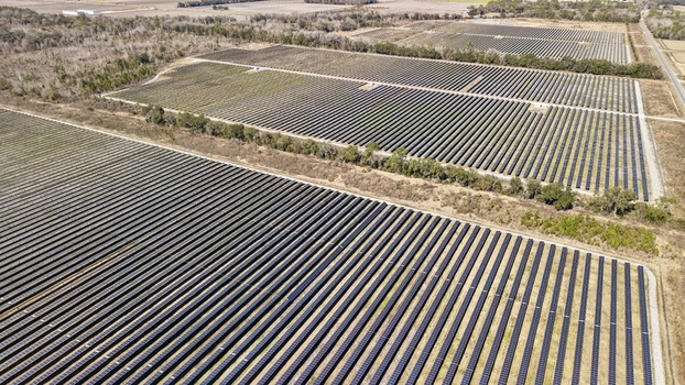 Aerial view of rows of solar panels reflecting sunlight creating a shimmering grid across the landscape Elkton Florida United States. Aerial view of rows of solar panels reflecting sunlight creating a shimmering grid across the landscape Elkton Florida United States.