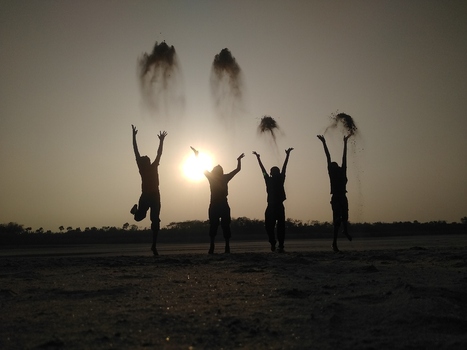 View of silhouettes of four people jumping and throwing sand into the air against a bright sunset sky on a riverbank in Kushtia Khulna Division Bangladesh. View of silhouettes of four people jumping and throwing sand into the air against a bright sunset sky on a riverbank in Kushtia Khulna Division Bangladesh.