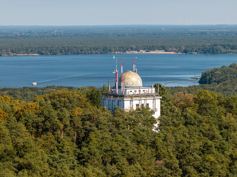 Aerial view of the iconic Muggelturm tower rising above the dense forest canopy with the expansive Muggelsee lake in the background in Berlin Berlin Germany. Aerial view of the iconic Muggelturm tower rising above the dense forest canopy with the expansive Muggelsee lake in the background in Berlin Berlin Germany.