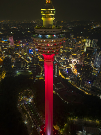 Kuala Lumpur Malaysia 11 March 2026 Aerial view of the Menara Kuala Lumpur tower illuminated in red light against the night city skyline and urban landscape.