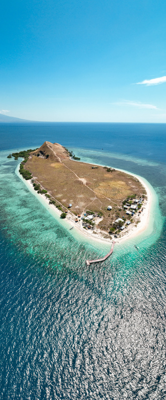 Aerial view of Pulau Kenawa with its grassy hills sandy beach wooden pier and turquoise waters in Poto Tano West Nusa Tenggara Indonesia. Aerial view of Pulau Kenawa with its grassy hills sandy beach wooden pier and turquoise waters in Poto Tano West Nusa Tenggara Indonesia.