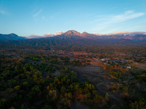 Aerial view of Savana Tianyar and Mount Abang at sunrise with lush green vegetation and volcanic terrain in Kecamatan Kubu Bali Indonesia. Aerial view of Savana Tianyar and Mount Abang at sunrise with lush green vegetation and volcanic terrain in Kecamatan Kubu Bali Indonesia.
