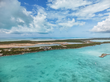 Aerial view of Man O War Cay Sandbar and the turquoise waters of the coastline under a blue sky with white clouds Rolletown Exuma The Bahamas. Aerial view of Man O War Cay Sandbar and the turquoise waters of the coastline under a blue sky with white clouds Rolletown Exuma The Bahamas.