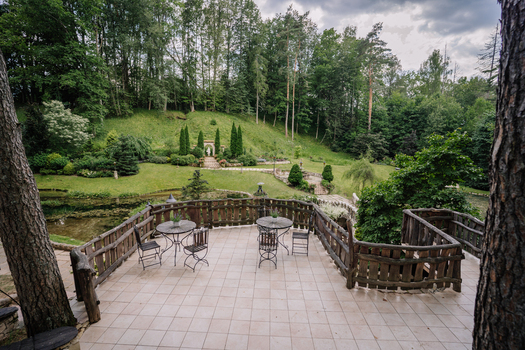 Cesis Latvia 17 July 2025 View of a beautifully landscaped private garden and park featuring decorative ponds stone pathways sculptures and a recreation terrace with metal furniture.