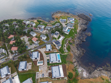 Aerial view of modern villas with swimming pools nestled along the rocky coastline of Arapya surrounded by lush greenery and the deep blue waters of the Black Sea Burgas Bulgaria. Aerial view of modern villas with swimming pools nestled along the rocky coastline of Arapya surrounded by lush greenery and the deep blue waters of the Black Sea Burgas Bulgaria.