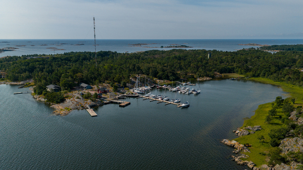 Aerial view of the marina at Oro Fortress Island with docked sailboats wooden piers and surrounding lush forest on the rocky coastline in Oro Varsinais Suomi Finland. Aerial view of the marina at Oro Fortress Island with docked sailboats wooden piers and surrounding lush forest on the rocky coastline in Oro Varsinais Suomi Finland.