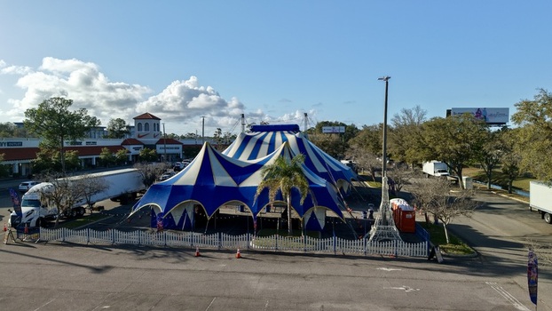 Aerial view of a striking blue and white striped circus tent pitched in a parking lot contrasting against the surrounding buildings and trees St. Augustine Florida United States. Aerial view of a striking blue and white striped circus tent pitched in a parking lot contrasting against the surrounding buildings and trees St. Augustine Florida United States.