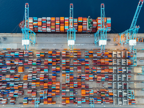 Aerial view of the semi automated container port with large cranes stacks of colorful shipping containers and a cargo ship docked at the pier in Vado Ligure Liguria Italy. Aerial view of the semi automated container port with large cranes stacks of colorful shipping containers and a cargo ship docked at the pier in Vado Ligure Liguria Italy.