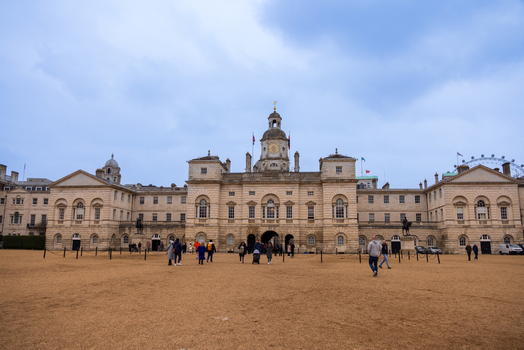 London United Kingdom 12 May 2025 View of the historic Horse Guards Parade building with people walking across the gravel square under an overcast sky.
