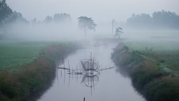 View of fishing nets in a misty river Bangladesh.