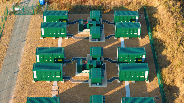 Aerial view of the Battery Energy park BESS Grendon featuring rows of green containerized battery storage units on a gravel site in Northampton England United Kingdom. Aerial view of the Battery Energy park BESS Grendon featuring rows of green containerized battery storage units on a gravel site in Northampton England United Kingdom.