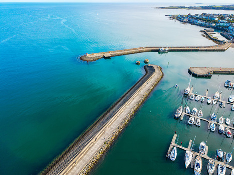 Aerial view of Bangor Harbour and Town with sailboats moored in the marina stone breakwaters and clear blue water in Bangor Northern Ireland United Kingdom.