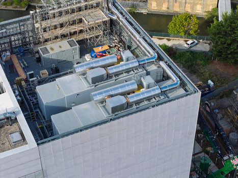 Aerial view of a data center rooftop featuring industrial HVAC units ventilation pipes and scaffolding in the United Kingdom. Aerial view of a data center rooftop featuring industrial HVAC units ventilation pipes and scaffolding in the United Kingdom.