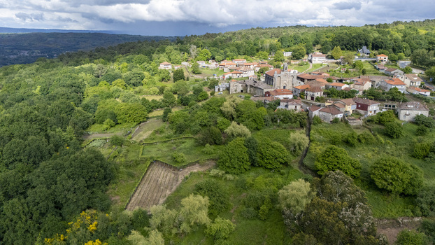 Aerial view of Iglesia de Santa Marina de Augas Santas and the historic village surrounded by lush green forests and rolling hills in Augas Santas Ourense Spain. Aerial view of Iglesia de Santa Marina de Augas Santas and the historic village surrounded by lush green forests and rolling hills in Augas Santas Ourense Spain.
