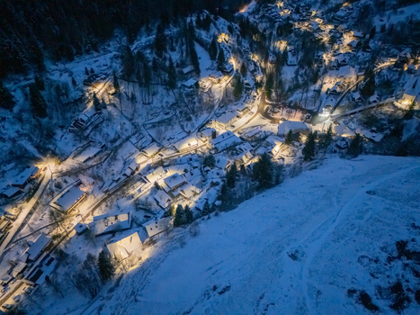 Aerial view of the historic mining village of Spania Dolina with snow covered rooftops and warm lights nestled in a winter valley at night Spania Dolina Banska Bystrica Region Slovakia. Aerial view of the historic mining village of Spania Dolina with snow covered rooftops and warm lights nestled in a winter valley at night Spania Dolina Banska Bystrica Region Slovakia.