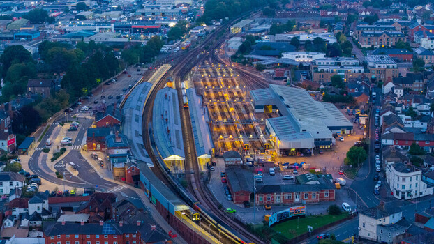 Aerial view of Salisbury railway station with multiple tracks platforms and trains illuminated at dusk in the surrounding urban landscape of Salisbury England United Kingdom. Aerial view of Salisbury railway station with multiple tracks platforms and trains illuminated at dusk in the surrounding urban landscape of Salisbury England United Kingdom.