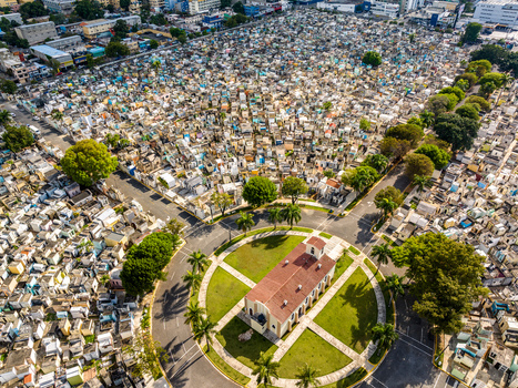 Aerial view of Maximo Gomez National Cemetery with dense rows of tombs pathways and a central chapel surrounded by palm trees in Santo Domingo Distrito Nacional Dominican Republic. Aerial view of Maximo Gomez National Cemetery with dense rows of tombs pathways and a central chapel surrounded by palm trees in Santo Domingo Distrito Nacional Dominican Republic.