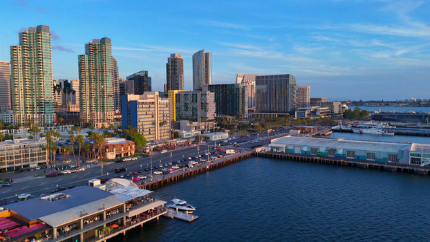 Aerial view of North Harbor Drive and North Embarcadero waterfront featuring modern skyscrapers boats docked at the pier and palm trees in San Diego California United States.