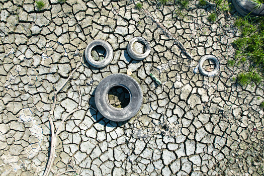 Aerial view of discarded tires on dry cracked earth during a severe drought in Carignano Piemonte Italy. Aerial view of discarded tires on dry cracked earth during a severe drought in Carignano Piemonte Italy.