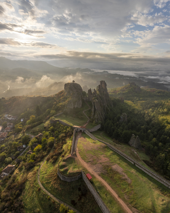 Aerial view of Belogradchik Fortress surrounded by dramatic rock formations lush greenery and rolling hills under a soft morning sky in Belogradchik Vidin Bulgaria. Aerial view of Belogradchik Fortress surrounded by dramatic rock formations lush greenery and rolling hills under a soft morning sky in Belogradchik Vidin Bulgaria.