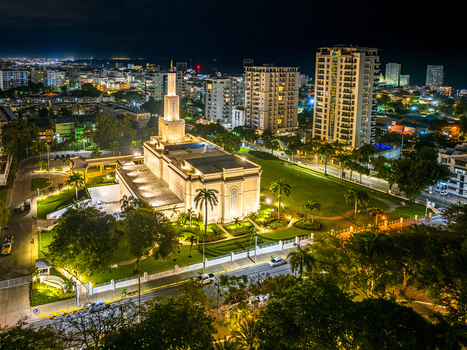 Aerial view of the Santo Domingo Dominican Republic Temple illuminated at night surrounded by lush gardens and the urban skyline of Santo Domingo Distrito Nacional Dominican Republic.