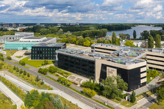 Aerial view of the Poznan University of Technology Warta Campus featuring modern glass and dark paneled academic buildings green lawns and nearby riverfront in Poznan Greater Poland Voivod Poland. Aerial view of the Poznan University of Technology Warta Campus featuring modern glass and dark paneled academic buildings green lawns and nearby riverfront in Poznan Greater Poland Voivod Poland.