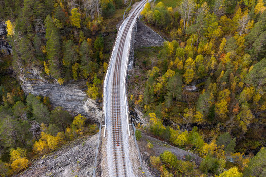 Aerial view of the historic Kylling Bridge railway viaduct surrounded by dense autumn forests and rocky cliffs in Verma More og Romsdal Norway. Aerial view of the historic Kylling Bridge railway viaduct surrounded by dense autumn forests and rocky cliffs in Verma More og Romsdal Norway.