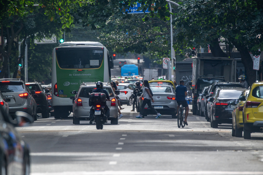 Rio de Janeiro Brazil 13 June 2026 View of heavy traffic with a bus cars and a motorcycle on a tree lined street in the Copacabana neighborhood.
