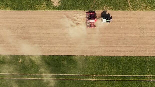 Aerial view of a tractor working in a field in Czechia. Aerial view of a tractor working in a field in Czechia.