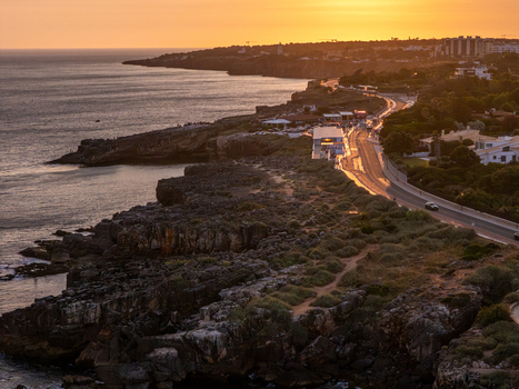 Aerial view of Boca do Inferno at sunset with rugged cliffs coastal road and the Atlantic Ocean in Cascais Lisboa Portugal. Aerial view of Boca do Inferno at sunset with rugged cliffs coastal road and the Atlantic Ocean in Cascais Lisboa Portugal.