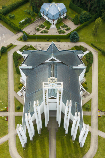 Aerial view of the modern Church of the Holy Virgin Mary with its distinctive white pillars and green roof surrounded by manicured lawns and pathways in Elektrenai Vilnius County Lithuania. Aerial view of the modern Church of the Holy Virgin Mary with its distinctive white pillars and green roof surrounded by manicured lawns and pathways in Elektrenai Vilnius County Lithuania.