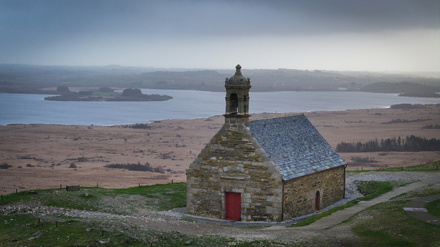 Aerial view of Mont Saint Michel de Brasparts chapel overlooking the Lac de Brennilis and the rugged moorland under a cloudy sky in Saint Rivoal Bretagne France. Aerial view of Mont Saint Michel de Brasparts chapel overlooking the Lac de Brennilis and the rugged moorland under a cloudy sky in Saint Rivoal Bretagne France.