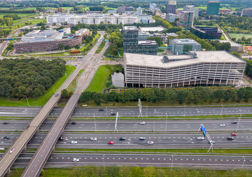 Utrecht Netherlands 13 September 2026 Aerial view of Utrecht Science Park with modern office buildings a large parking structure and green spaces adjacent to a multi lane highway.