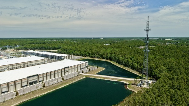 Aerial view of industrial warehouses and a telecommunications tower by retention ponds and a dense forest at Saint Johns Parkway in World Golf Village Florida United States. Aerial view of industrial warehouses and a telecommunications tower by retention ponds and a dense forest at Saint Johns Parkway in World Golf Village Florida United States.