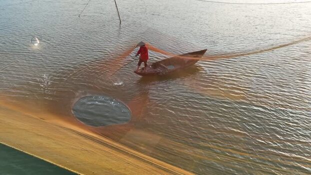 Aerial view of fisherman casting net on Thu Bon River Vietnam. Aerial view of fisherman casting net on Thu Bon River Vietnam.