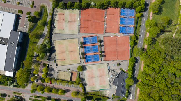 Aerial view of Tennis Padel Club Heiloo showing various tennis and padel courts with colorful surfaces surrounded by green trees and local roads Heiloo Noord Holland Netherlands.