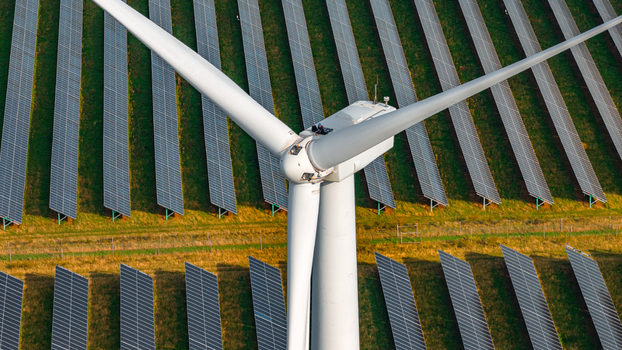 Aerial view of the Chelveston Renewable Energy wind turbine surrounded by extensive rows of solar panels in a green field in Chelveston England United Kingdom. Aerial view of the Chelveston Renewable Energy wind turbine surrounded by extensive rows of solar panels in a green field in Chelveston England United Kingdom.