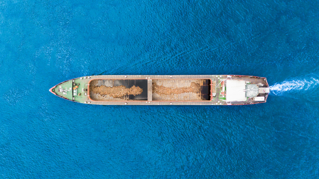 Aerial view of a large cargo barge transporting bulk materials across the deep blue waters of the Danube river in Novi Sad Vojvodina Serbia. Aerial view of a large cargo barge transporting bulk materials across the deep blue waters of the Danube river in Novi Sad Vojvodina Serbia.