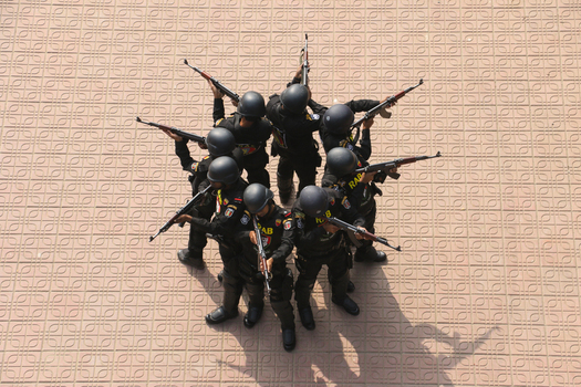 Dhaka Bangladesh 06 January 2017 View of Rapid Action Battalion RAB officers in black uniforms and helmets aiming rifles in a circular formation at the RAB Headquarters. Dhaka Bangladesh 06 January 2017 View of Rapid Action Battalion RAB officers in black uniforms and helmets aiming rifles in a circular formation at the RAB Headquarters.