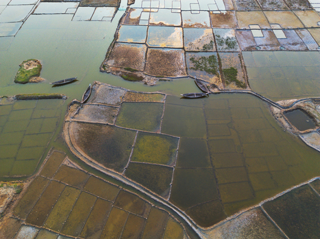 Aerial view of geometric salt pans and traditional wooden boats in the narrow water channels of Moheskhali Upazila Chittagong Division Bangladesh. Aerial view of geometric salt pans and traditional wooden boats in the narrow water channels of Moheskhali Upazila Chittagong Division Bangladesh.