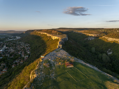 Aerial view of the historic Ovech Fortress situated on a rocky plateau at golden hour with the Bulgarian flag waving and the town of Provadia in the background Provadia Varna Bulgaria. Aerial view of the historic Ovech Fortress situated on a rocky plateau at golden hour with the Bulgarian flag waving and the town of Provadia in the background Provadia Varna Bulgaria.