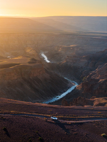 Aerial view of the winding Fish River cutting through the arid landscape the golden light casting long shadows and illuminating the rugged terrain Fish River Canyon Karas Region Namibia. Aerial view of the winding Fish River cutting through the arid landscape the golden light casting long shadows and illuminating the rugged terrain Fish River Canyon Karas Region Namibia.