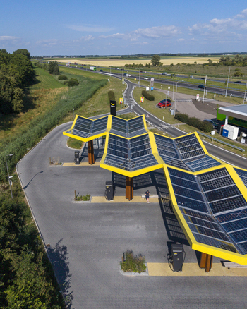 Aerial view of the Fastned Charging Station with its distinctive yellow solar panel roof situated along a highway in Lelystad Flevoland Netherlands. Aerial view of the Fastned Charging Station with its distinctive yellow solar panel roof situated along a highway in Lelystad Flevoland Netherlands.