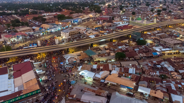 Aerial view of the Tamale Interchange spanning across the urban landscape with a mosque featuring a green dome busy streets and dense rooftops in Tamale Northern Region Ghana.