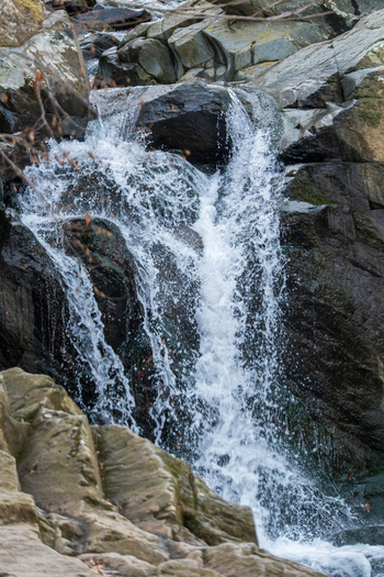 View of cascading water flowing powerfully over dark rocks creating a mesmerizing spectacle in Scott s Run Nature Preserve Scott s Run Virginia United States. View of cascading water flowing powerfully over dark rocks creating a mesmerizing spectacle in Scott s Run Nature Preserve Scott s Run Virginia United States.