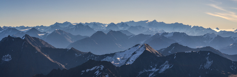 Aerial view of Chugach State Park featuring rugged snow capped mountain peaks glaciers and deep valleys under a clear sky in Anchorage Alaska United States. Aerial view of Chugach State Park featuring rugged snow capped mountain peaks glaciers and deep valleys under a clear sky in Anchorage Alaska United States.