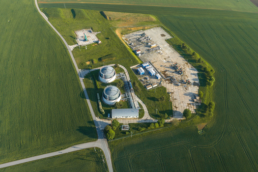 Aerial view of the UGS Damborice facility with large storage tanks and industrial structures surrounded by green agricultural fields in Damborice South Moravian Region Czechia. Aerial view of the UGS Damborice facility with large storage tanks and industrial structures surrounded by green agricultural fields in Damborice South Moravian Region Czechia.