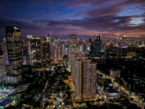 Aerial view of the illuminated skyscrapers along Jalan Jendral Sudirman at dusk in Kecamatan Setiabudi Daerah Khusus Ibukota Indonesia. Aerial view of the illuminated skyscrapers along Jalan Jendral Sudirman at dusk in Kecamatan Setiabudi Daerah Khusus Ibukota Indonesia.