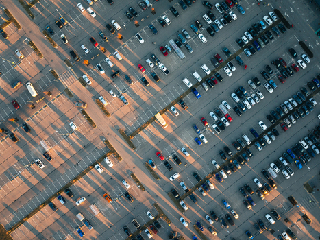 Aerial view of a large parking lot filled with cars during sunset in Ulbroka Ropazi Municipality Latvia.